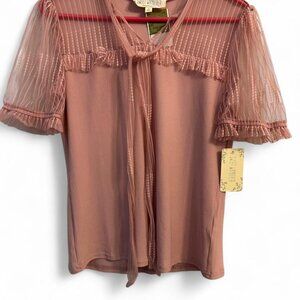 Sweet Wanderer pink blouse with sheer ruffle sleeves and tie detail.